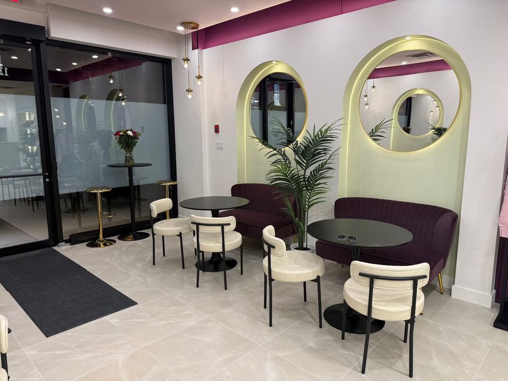 The two arches with lit round mirrors, plum settees and a palm.