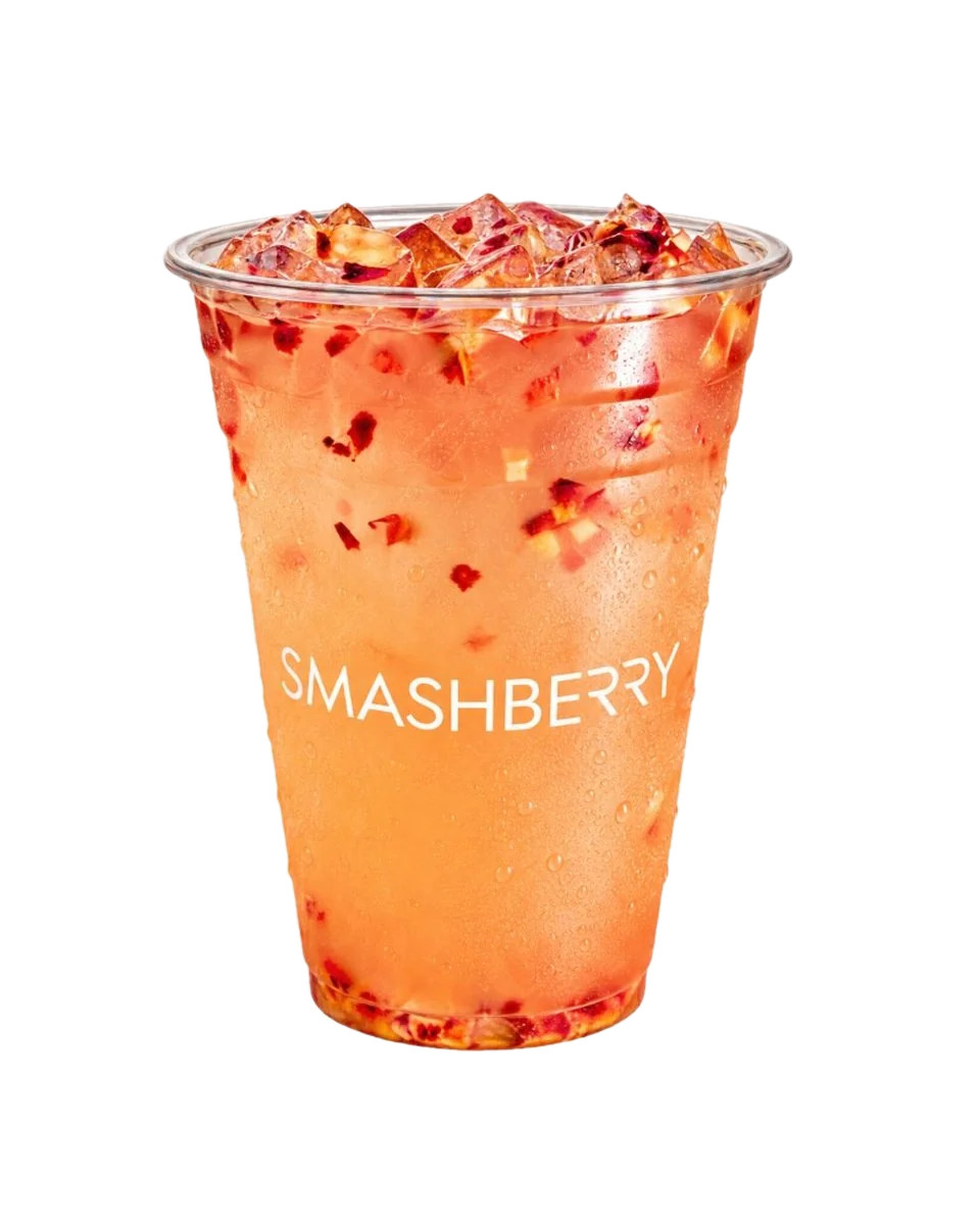 Lychee Rose refresher, orange, with red fruit pieces, Smashberry cup.