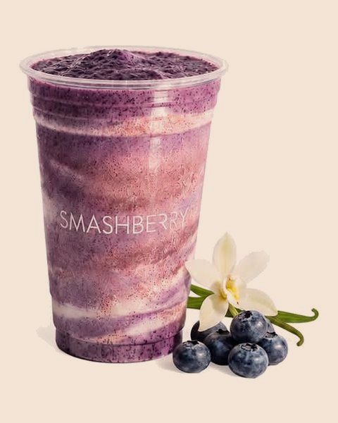 Blueberry Vanilla smoothie, swirled violet, with blueberries and a vanilla flower.
